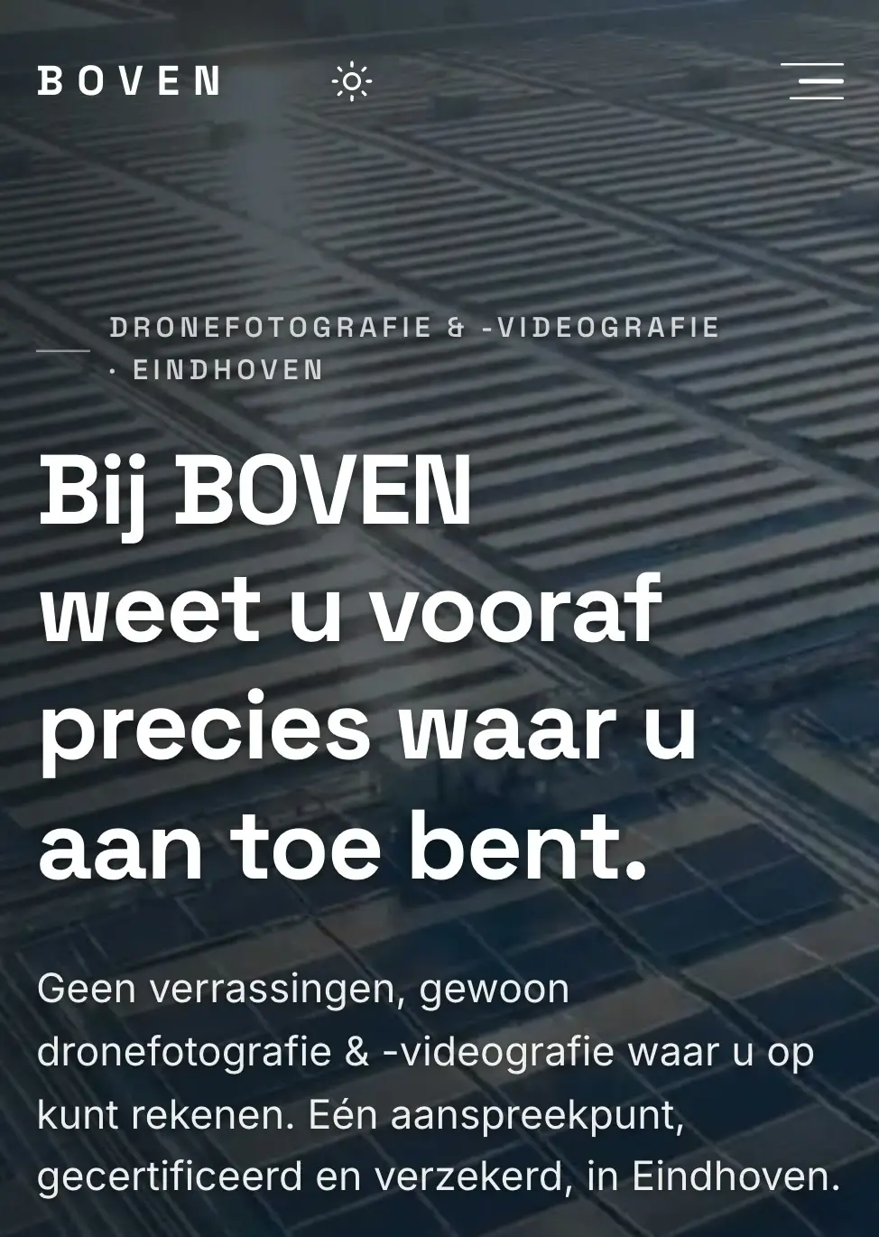 De homepage van voorbeeldzaak BOVEN op een telefoon: een luchtfoto van daken