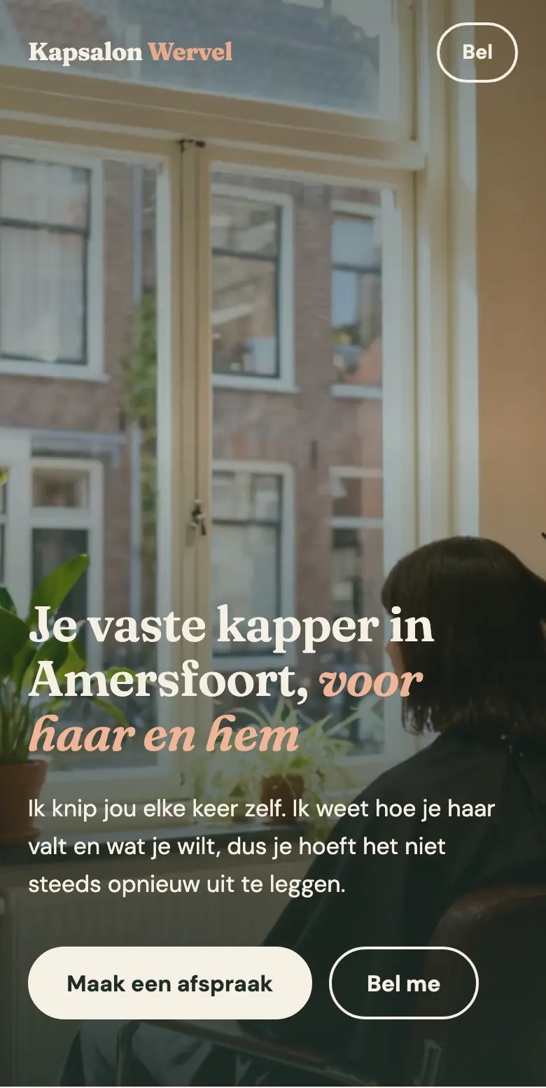 Telefoonscherm van de homepage van Kapsalon Wervel: een grote foto van een klant bij het raam, de kop "Je vaste kapper in Amersfoort, voor haar en hem" en de knoppen "Maak een afspraak" en "Bel me".