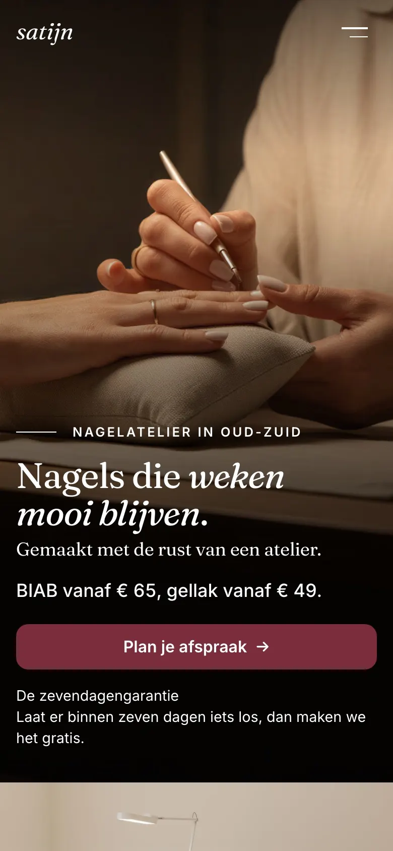 De home van Satijn op een telefoon: een foto over het hele scherm van twee handen met melkwitte nagels op een kussen, een stift in de ene hand, daaronder de kop Nagels die weken mooi blijven en een bordeaux knop Plan je afspraak